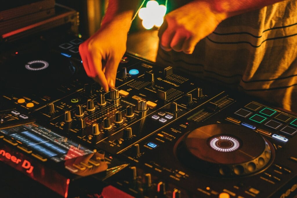 person playing dj mixer with vinyl record